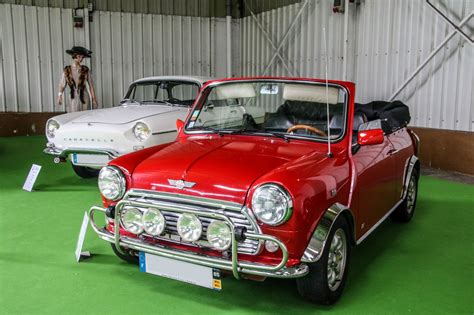 Two Classic Cars Are On Display In A Building With Green Flooring And