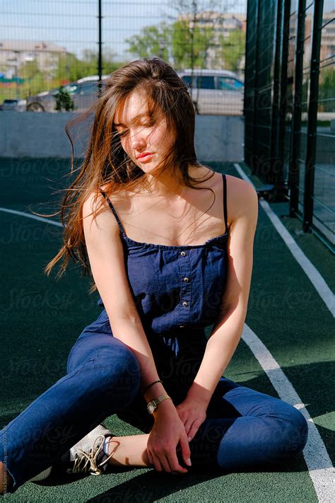 Portrait Of A Beautiful Girl Sitting On A Basketball Court By Stocksy Contributor Nikita