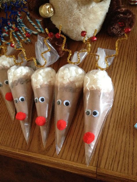 Four Reindeer Cones With Candy On Them Sitting On A Table Next To A