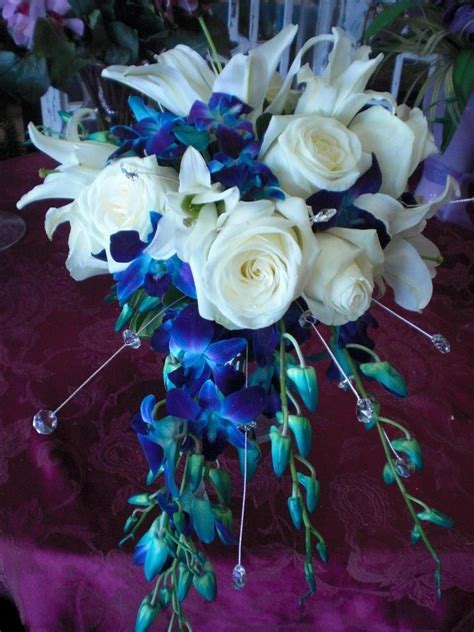 cascading bouquet of white oriental lilies white roses and blue dendrobium orchids blue