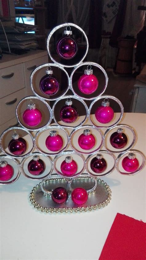 A Christmas Tree Made Out Of Wine Glasses With Ornaments On The Top And