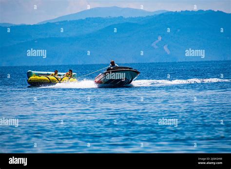tourists enjoy inflatable towable rides at koukounaries beach in skiathos island sporades