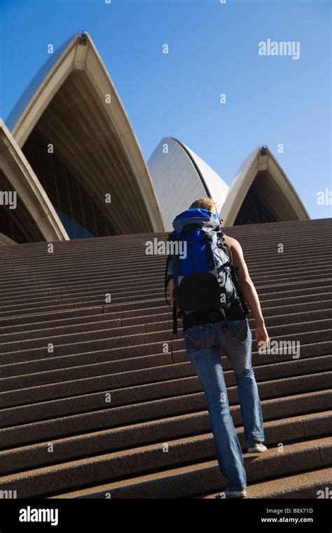 A Backpacker Climbs The Steps Of The Opera House In Sydney New South