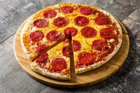 Pizza De Pepperoni Italiana Caliente En Mesa De Madera Foto Premium