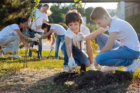 Colegiales plantando árboles frutales jóvenes 2022