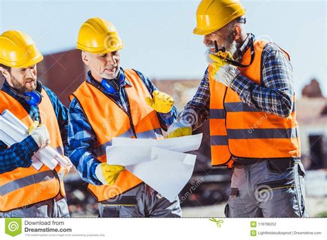 The amendment, namely 34a in ubbl, makes it compulsory for. Three Workers In Uniform Examining Building Plans And ...