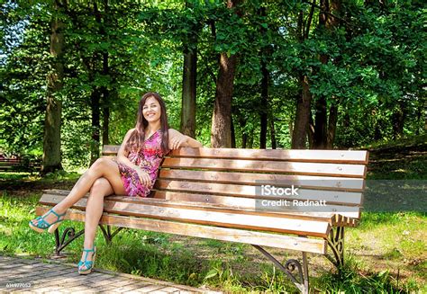 Young Beautiful Girl Sitting On A Park Bench Stock Photo Download