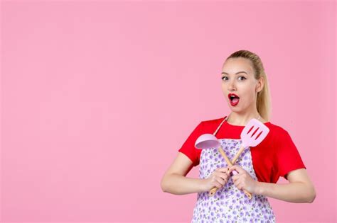 Free Photo Front View Young Housewife Posing With Cutlery In Her