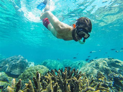 Young Man Diving And Snorkeling On Tropical Coral Reef On The Sea With Diving Mask And Tube