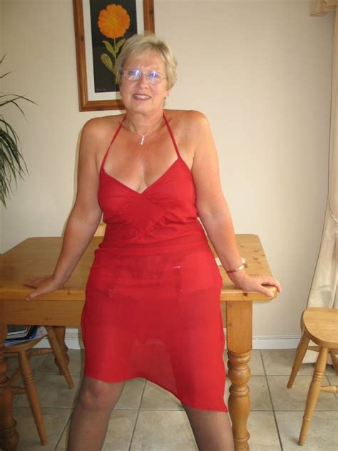 A Woman In A Red Dress Posing For The Camera
