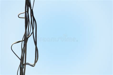 A Bunch Of Electrical Wires Hanging On Blue Background Stock Photo