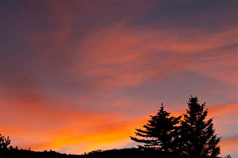 Colorful Sunset Behind Hills And Trees Stock Photo Download Image Now