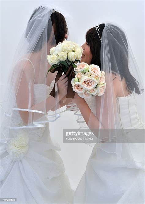 A Lesbian Couple Kisses As They Pose For Photos Taken By A Wedding