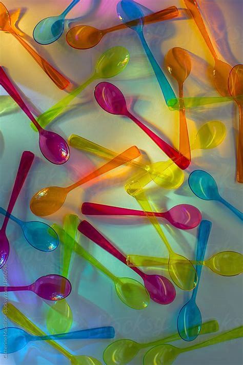 A Collection Of Coloured Plastic Spoons On A Brightly Coloured
