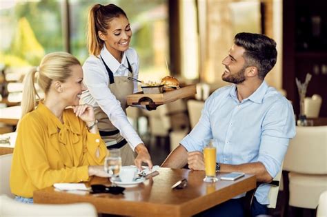 Premium Photo Happy Waitress Serving Food To A Couple In A Restaurant