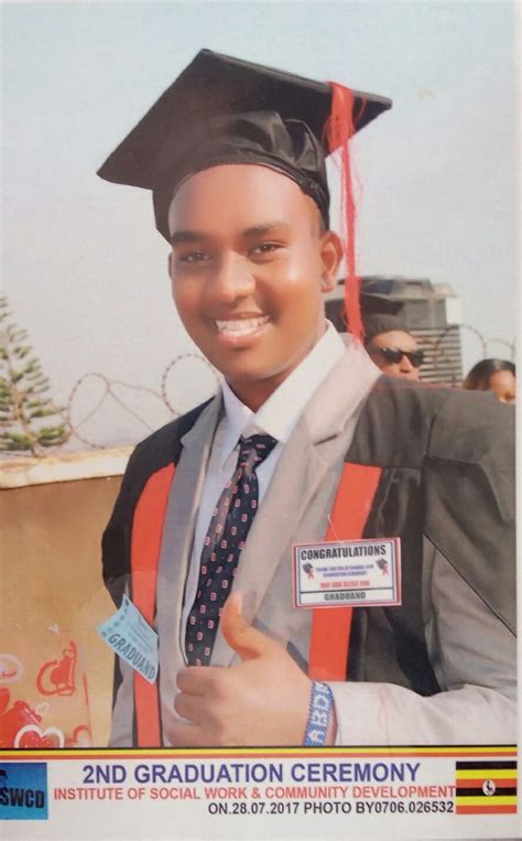 A Young Man Wearing A Graduation Cap And Gown Holding His Thumb Up To