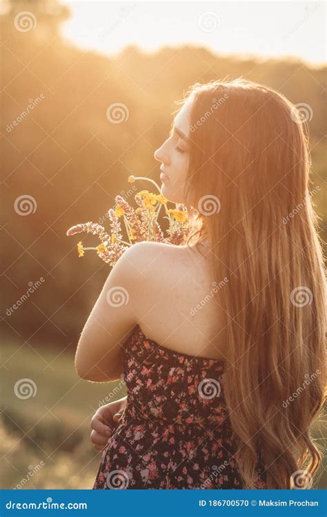 Romantic Girl With Bouquet Of Wildflowers On Meadow Young Woman With Long Hair In Dress Walking