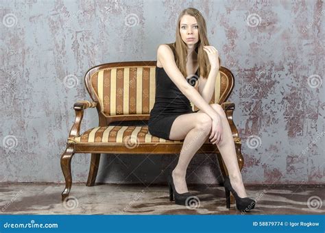 Piękna Długowłosa Młoda Blondynki Kobieta Z Nikłą Postacią W Czarnej Mini Sukni Zdjęcie Stock