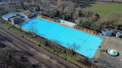 An Aerial View Of A Swimming Pool Surrounded By Train Tracks