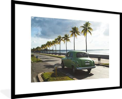 Fotolijst Incl Poster Een Groene Cubaanse Oldtimer Onder Palmbomen 90x60 Cm Bol Com