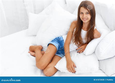 Lächelndes Jugendlich Mädchenporträt Auf Einem Bett Stockfoto Bild