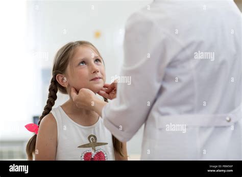 Little Child Girl Looking At Doctor Who Testing Her Tonsils Stock Photo