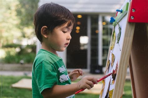 Little Kid Painting On Easel By Stocksy Contributor Lauren Lee