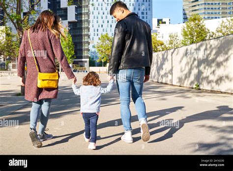 Parents Little Girl Holding Hands Walking Together In Barcelona Hi Res