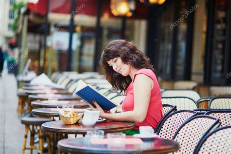 在传统的巴黎户外咖啡馆，巴黎，法国读书的女人 — 图库照片©encrier＃114549290