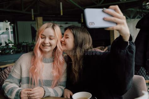 Cheerful Young Lesbian Couple Selfie Using Mobile Phone At A Coffee Shop Two Joyful Attractive