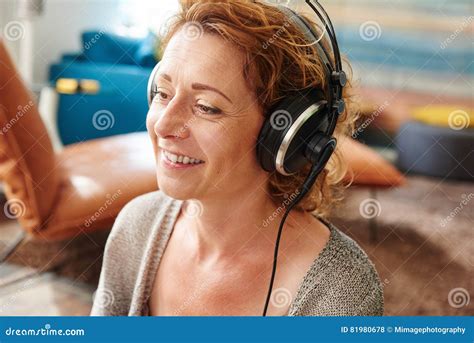 Older Woman Listening To Music With Headphones At Home Stock Photo