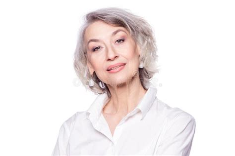 close up portrait of pleasant grey haired middle aged female looking at camera with a wide