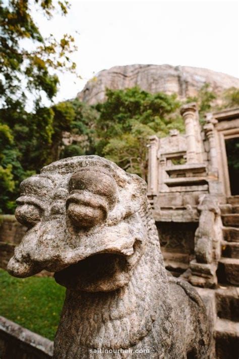 A Stone Lion Statue In Front Of An Ancient Building