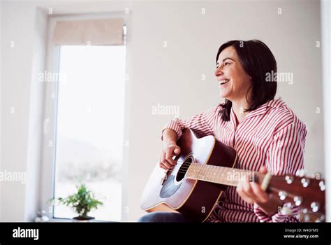 Happy Mature Woman Playing Guitar At Home Stock Photo Alamy