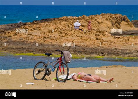 Crete Beach Holiday Woman Sunbathing On Beach At Malia On The Greek Mediterranean Island Of