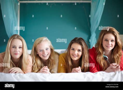 Portrait Of Four Teenage Girls Lying On Bed Stock Photo Alamy