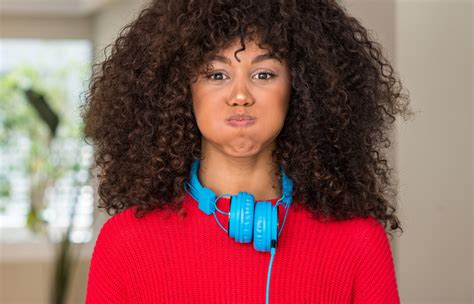 African American Woman Wearing Headphones Puffing Cheeks With Funny