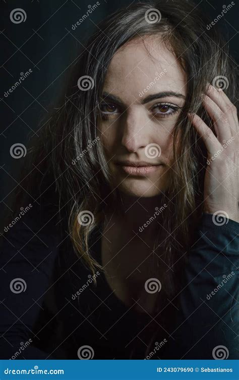 portrait of a beautiful italian girl with long hair with her hand in her hair with a seductive