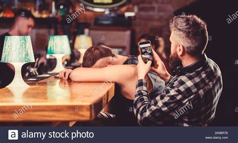 hipster taking photo drunk friend drunk friends in bar fall asleep at bar counter take photo