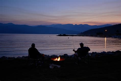 Silhouette Of Two Men Next To Calm Body Of Water Photo Free Flame