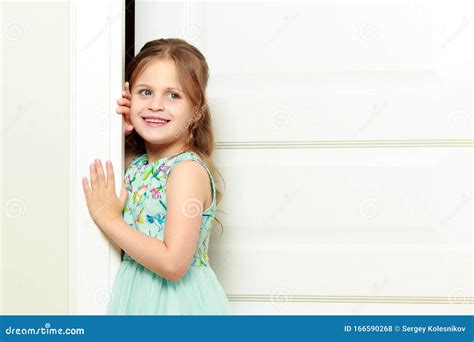 A Little Girl Is Standing By The Door Stock Photo Image Of Face