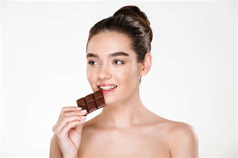 ダイエット中のチョコレートバーを食べて黒髪の空腹の半分裸の女性の素敵な画像 無料の写真