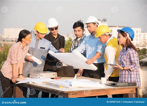 Group Of Engineers And Architects Discuss At A Construction Site Stock