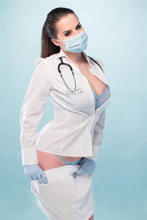 Sexy enfermera joven usando camisa blanca de manga larga y ropa interior de espalda con máscara