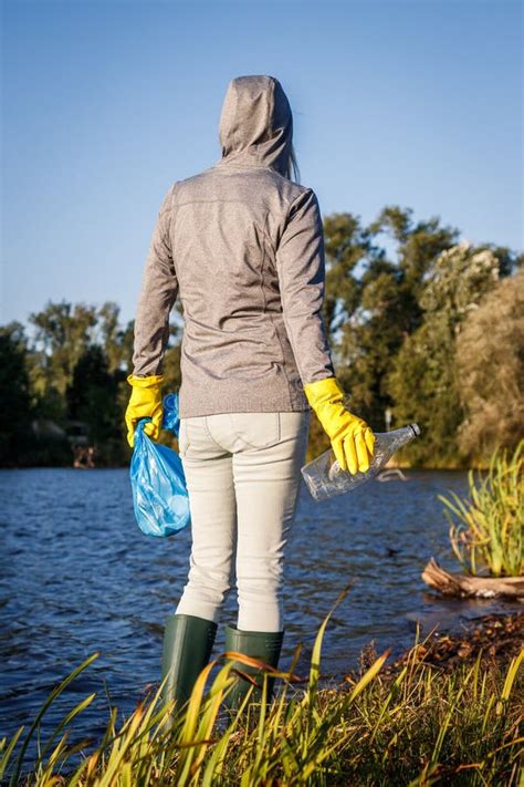 Environmental Volunteer With Protective Glove Holding Garbage Bag And