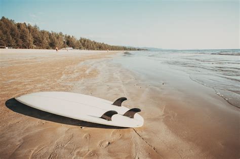 planche de surf sur la plage tropicale de sable avec paysage marin calme fond de mer et du ciel
