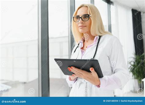 Portrait Of Beautiful Mature Woman Doctor Holding Digital Tablet Confident Female Doctor Using
