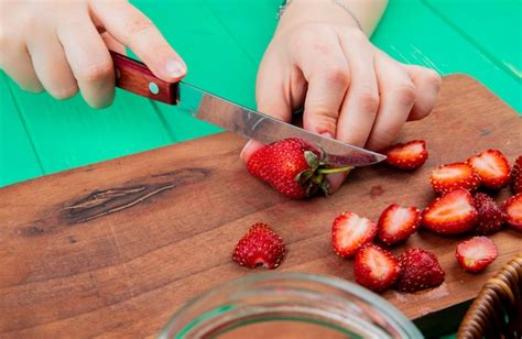 Free Photo Side View Of Hands Cutting Strawberries With Knife On
