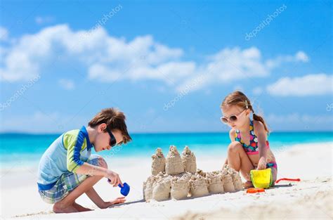 Two Kids Playing At Beach Stock Photo By ©shalamov 22112623