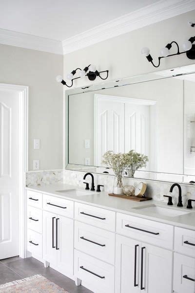 Add style and functionality to your bathroom with a bathroom vanity. These modern black vanity sconces pop so well against the ...